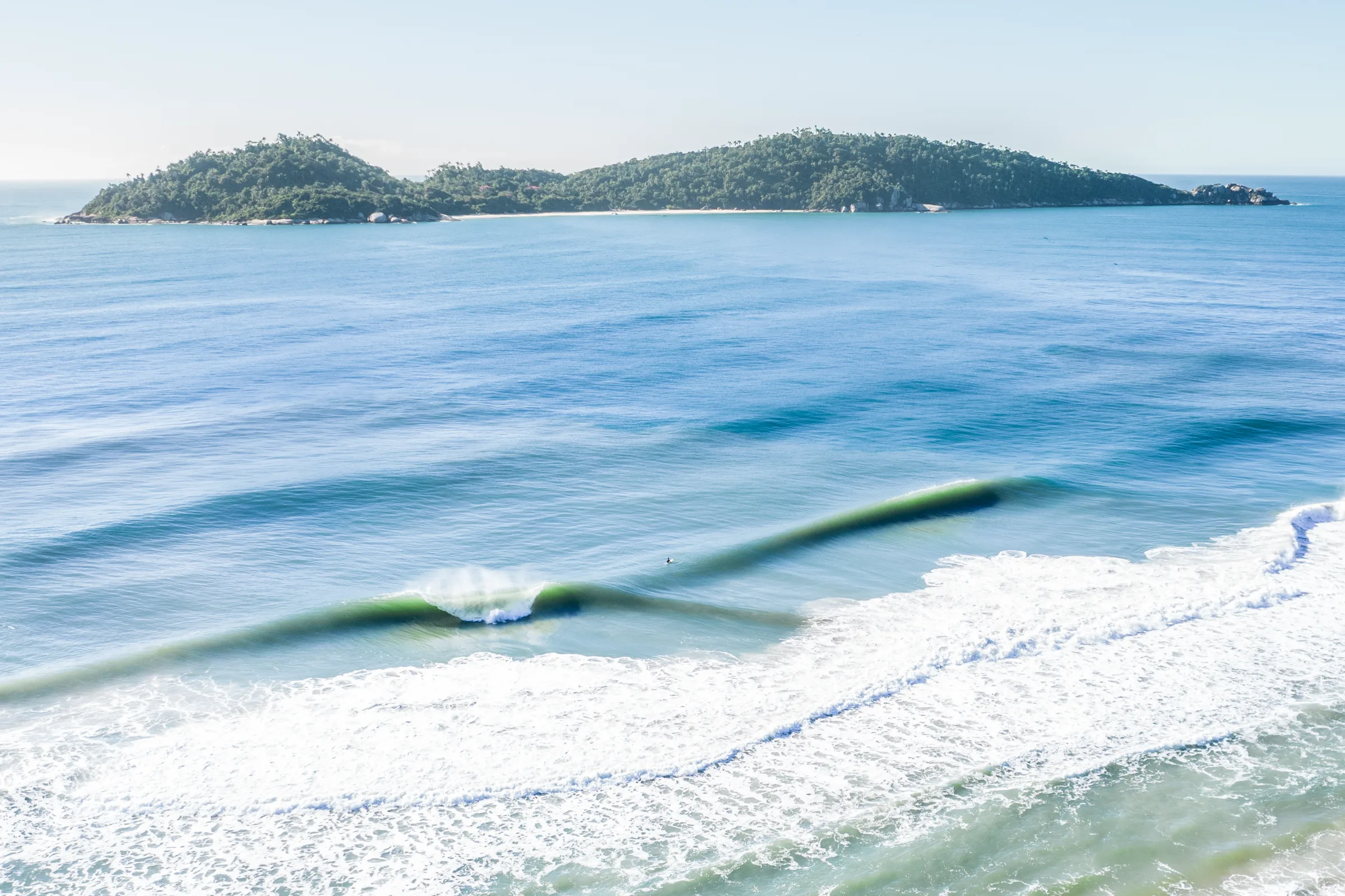 Vista aérea do litoral de Florianópolis, com ondas e ilhas preservadas